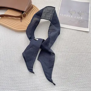 Detail of navy blue linen skinny scarf on white grid background with simple life decor