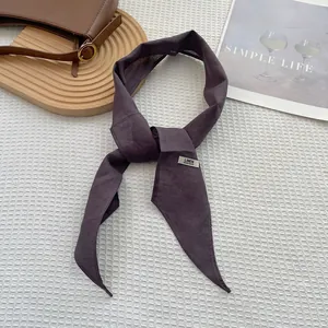 Close-up of a handmade linen scarf with a pointed end and Linen Hand Made label