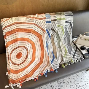 Detail of geometric sunshade shawl with fine tassels and vintage striped patterns
