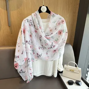 Detail of sheer summer scarf with pink floral prints and lightweight texture