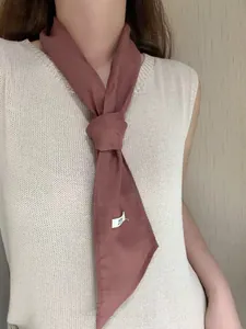 Close-up of pink 100% linen scarf showing texture and knot detail on model