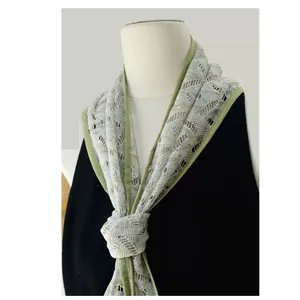 Detail of hollow knit cooling scarf with green edge piping and subtle sequins
