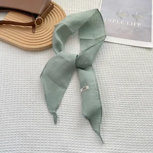 Detail of light green 100% linen skinny scarf featuring a handmade fabric texture