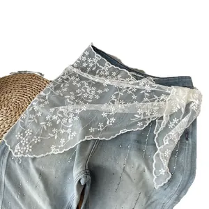 Pink lace triangle scarf with floral embroidery and rhinestones on light blue denim jeans