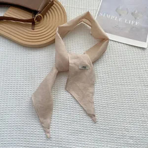 Macro detail of beige handmade linen scarf with woven label on waffle fabric background