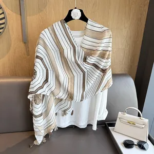 Close-up of geometric striped scarf with fringes styled with a handbag and sunglasses
