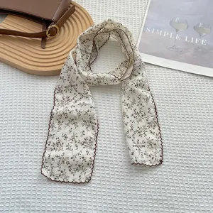 Detail of vintage floral cotton linen scarf with brown wavy edges on a white tray