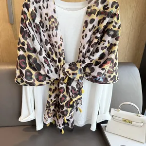 Sciarpa leopardata con frange gialle su camicia bianca per uno stile estivo casual