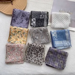 Posa piatta di nove foulard in seta con stampe floreali e leopardate e bordi rifiniti