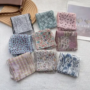Dettaglio di nove foulard con fantasie floreali e leopardate su tessuto a nido d'ape