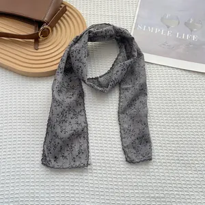 Close-up of floral cotton scarf with delicate black lace edges on a minimalist background