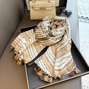Detail of vintage striped cotton linen scarf with elegant fringe tassels in soft tones