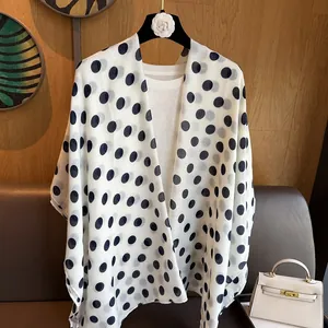 Close-up of lightweight chiffon shawl with black polka dots on white background