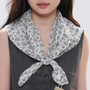Detail of ramie scarf featuring black floral patterns and vintage paisley style