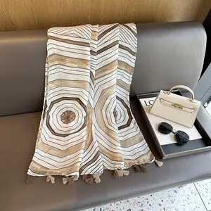 Detail view of geometric pattern scarf with fringes draped on a premium leather seat