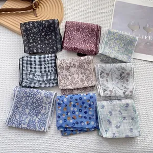 Vista dettagliata di nove foulard quadrati in seta con motivi floreali e a quadri