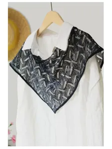 Detail of hollow lace shawl with black mesh and white embroidery with tiny sequins