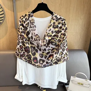 Dettaglio della sciarpa leopardata abbinata a top bianco e borsa bianca chic