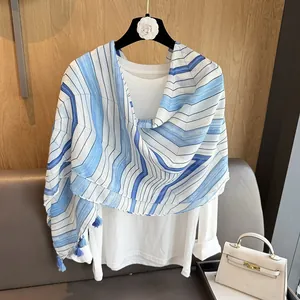 Close-up of blue and white striped cotton scarf featuring delicate edge tassels