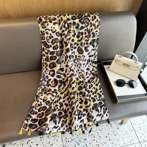 Dettaglio di una sciarpa leopardata con eleganti frange a nappa gialle e nere sui bordi