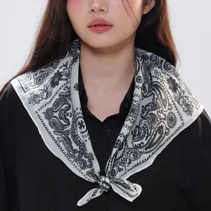 Detail of a natural ramie paisley scarf with black and white patterns tied around the neck