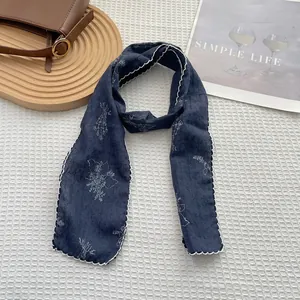 Close-up of floral navy blue cotton-linen scarf with white scalloped edge stitching