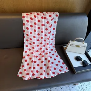 Detailed macro shot of white chiffon scarf with red polka dots on vintage leather bench