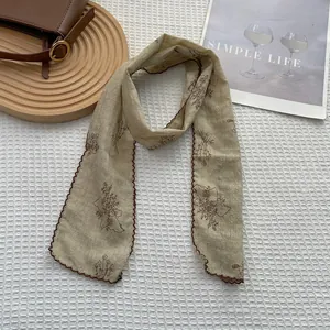 Detail of vintage floral cotton linen scarf with scalloped edges on minimalist background