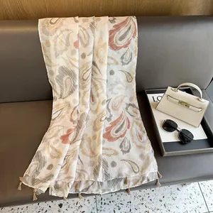 Vue détaillée d'une écharpe à motif paisley kaki avec des bordures à franges