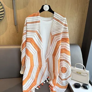 Detailed shot of striped sun-protection shawl with geometric pattern and orange tassels