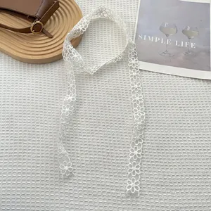 Detailopname van wit madeliefje kantlint gebruikt als elegante sjaal of haaraccessoire