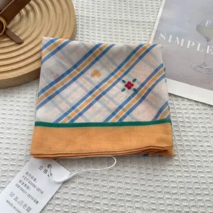 Blue and yellow plaid square scarf with red flowers and hearts on a waffle fabric background