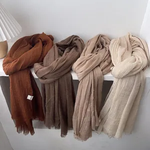 Bufandas de algodón y lino arrugado en tonos marrón y beige con bordes deshilachados