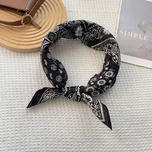 Κοντινό πλάνο από μαντήλι ραμί με σχέδιο paisley σε ξύλινο δίσκο και φόντο με υφή βάφλας