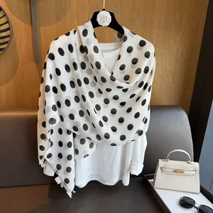 Elegant French retro white scarf with black polka dots draped over a white blouse
