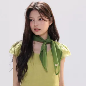 Close-up of grass green silk scarf tied in French style on a model neck with fine hem