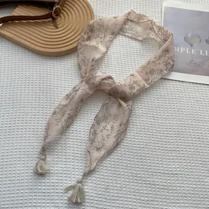 Dettaglio della sciarpa in chiffon a fiori con eleganti nappe e motivo vintage retrò