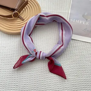 Detail of pink floral silk scarf tied elegantly on white waffle fabric with a leather bag