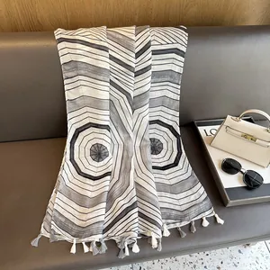 Detailed view of striped geometric patterns and grey fringe on a cotton linen shawl