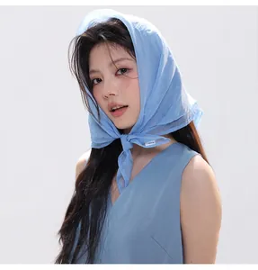 Detail showing sheer light blue scarf tied around neck with lightweight silky texture