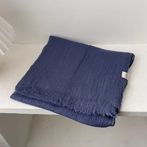 Detalle del pañuelo de lino azul marino con textura arrugada y borde de flecos
