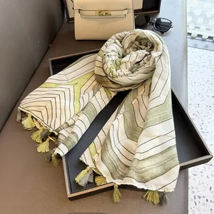 Detail of geometric pattern linen scarf with dual-tone tassels on black tray