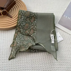 Detail of dark green striped floral scarf with be keen on tag on waffle texture