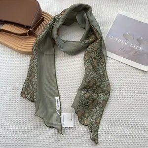 Detailed view of Morandi green striped silk scarf with floral patterns on waffle texture
