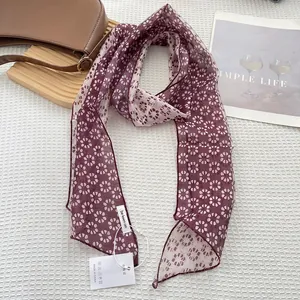 Close-up of deep purple floral skinny scarf on waffle texture with official tag
