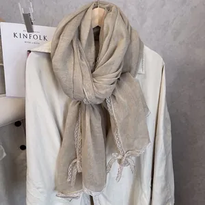 Elegant beige linen scarf with white lace trim and decorative bows for summer sun protection