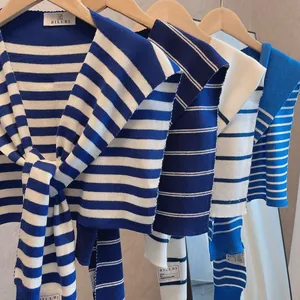 Close-up of knit striped nautical shawls in blue and white on wooden hangers