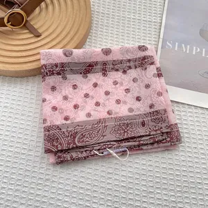 Detailed shot of pink paisley pattern square scarf on waffle texture background