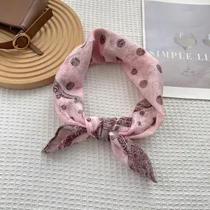 Detail of pink silk scarf with paisley pattern on white waffle texture and minimalist decor