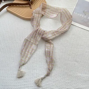 Dettaglio foulard in seta floreale con quadri viola giallo e nappe color crema